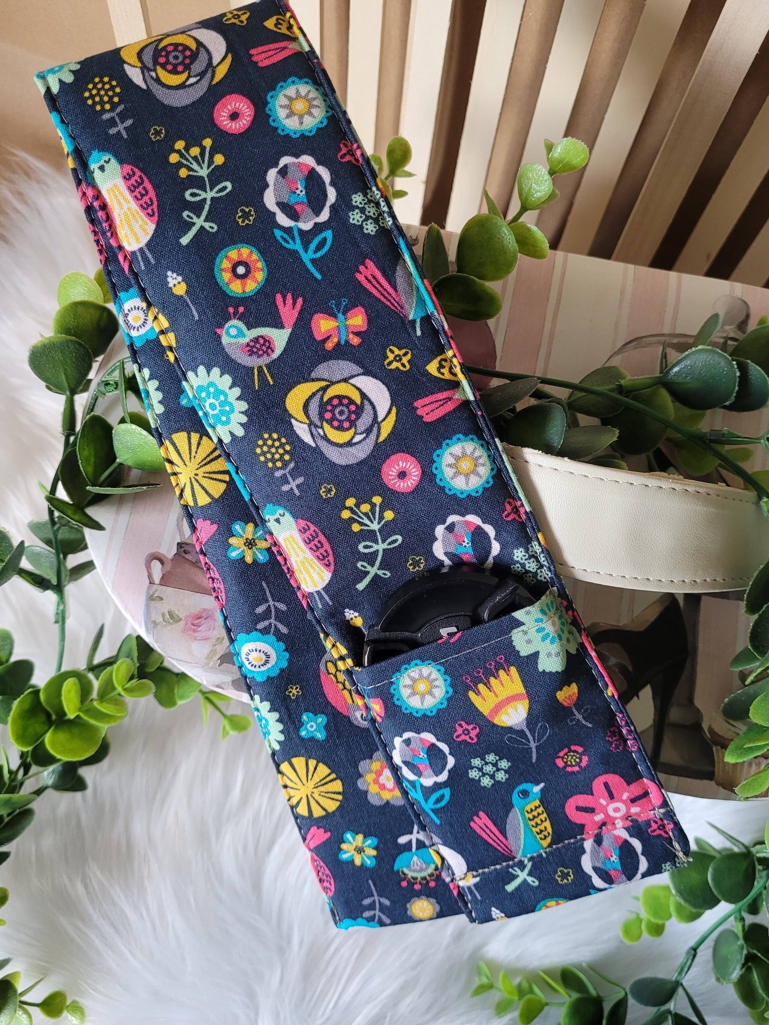 Camera strap cover with lens cap pocket