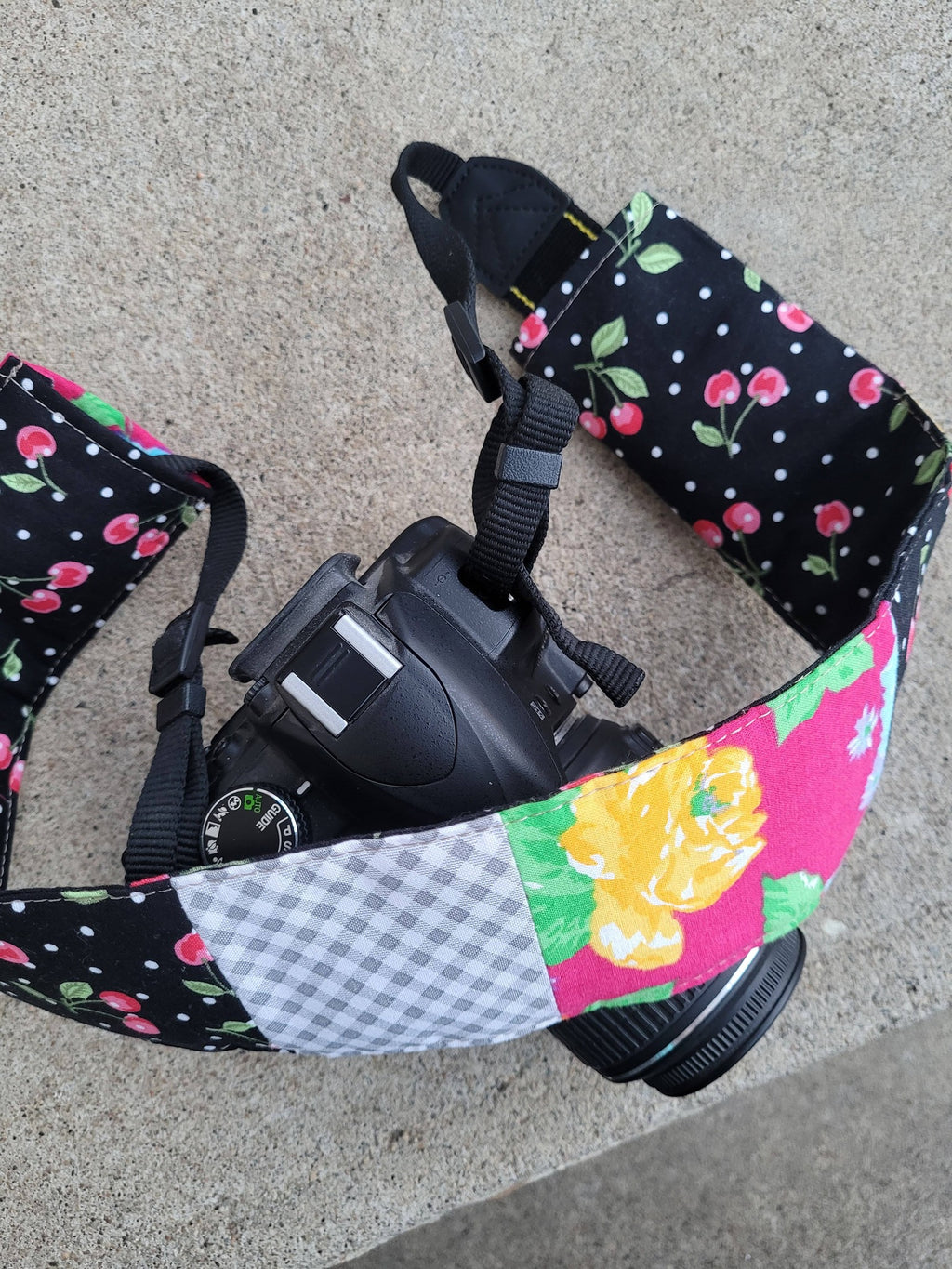 Camera strap cover with lens cap pocket.