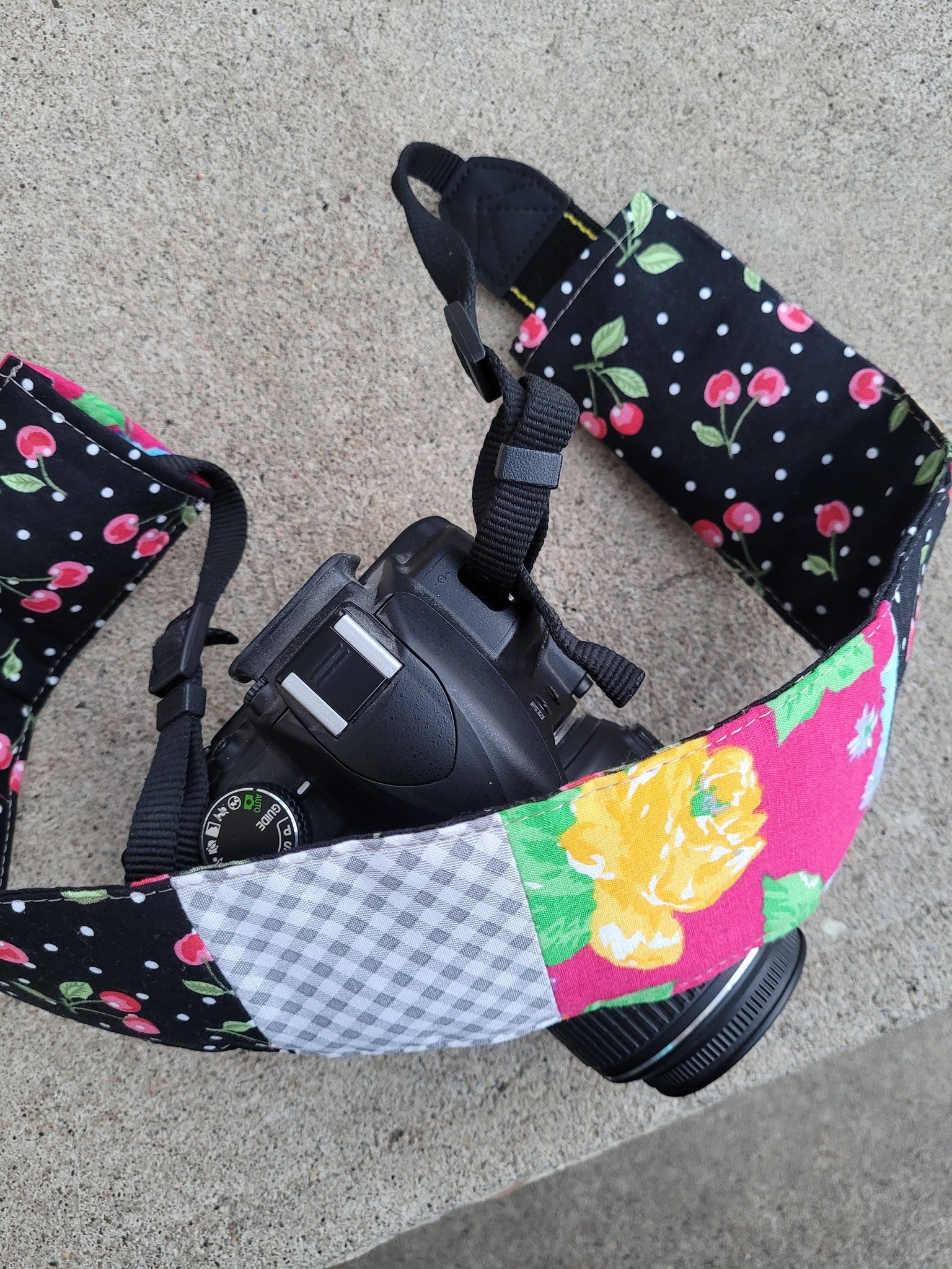 Camera strap cover with lens cap pocket.