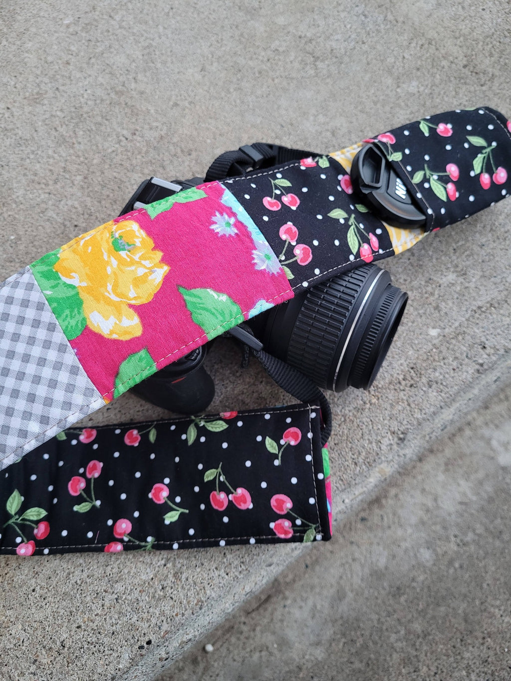 Camera strap cover with lens cap pocket.