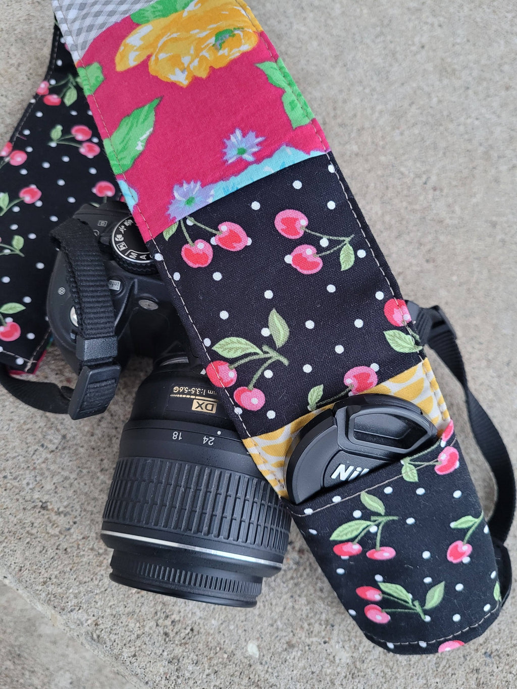 Camera strap cover with lens cap pocket