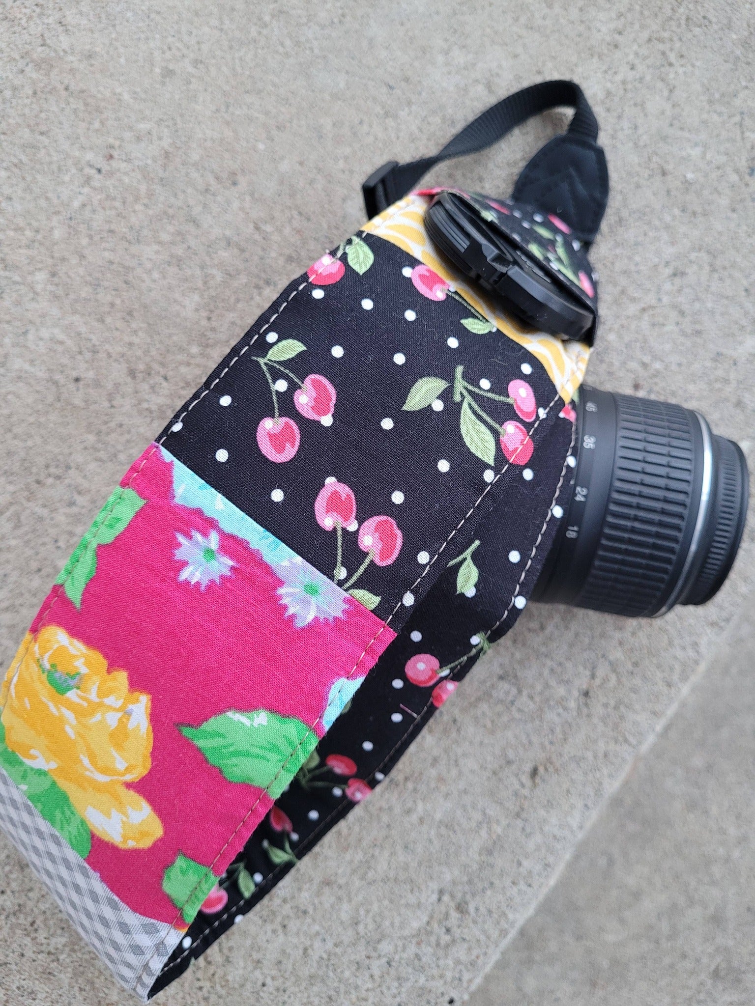 Camera strap cover with lens cap pocket.