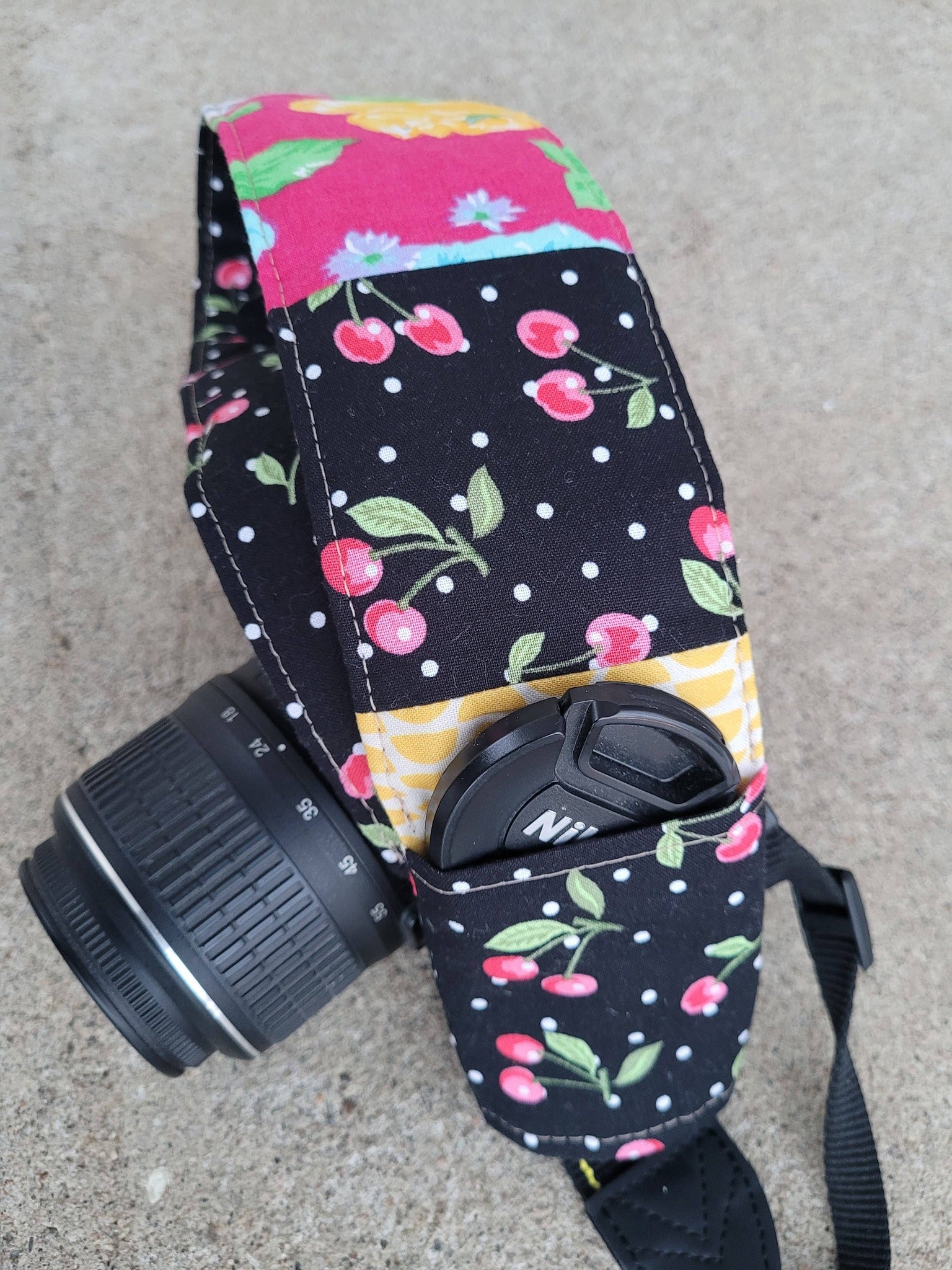 Camera strap cover with lens cap pocket.