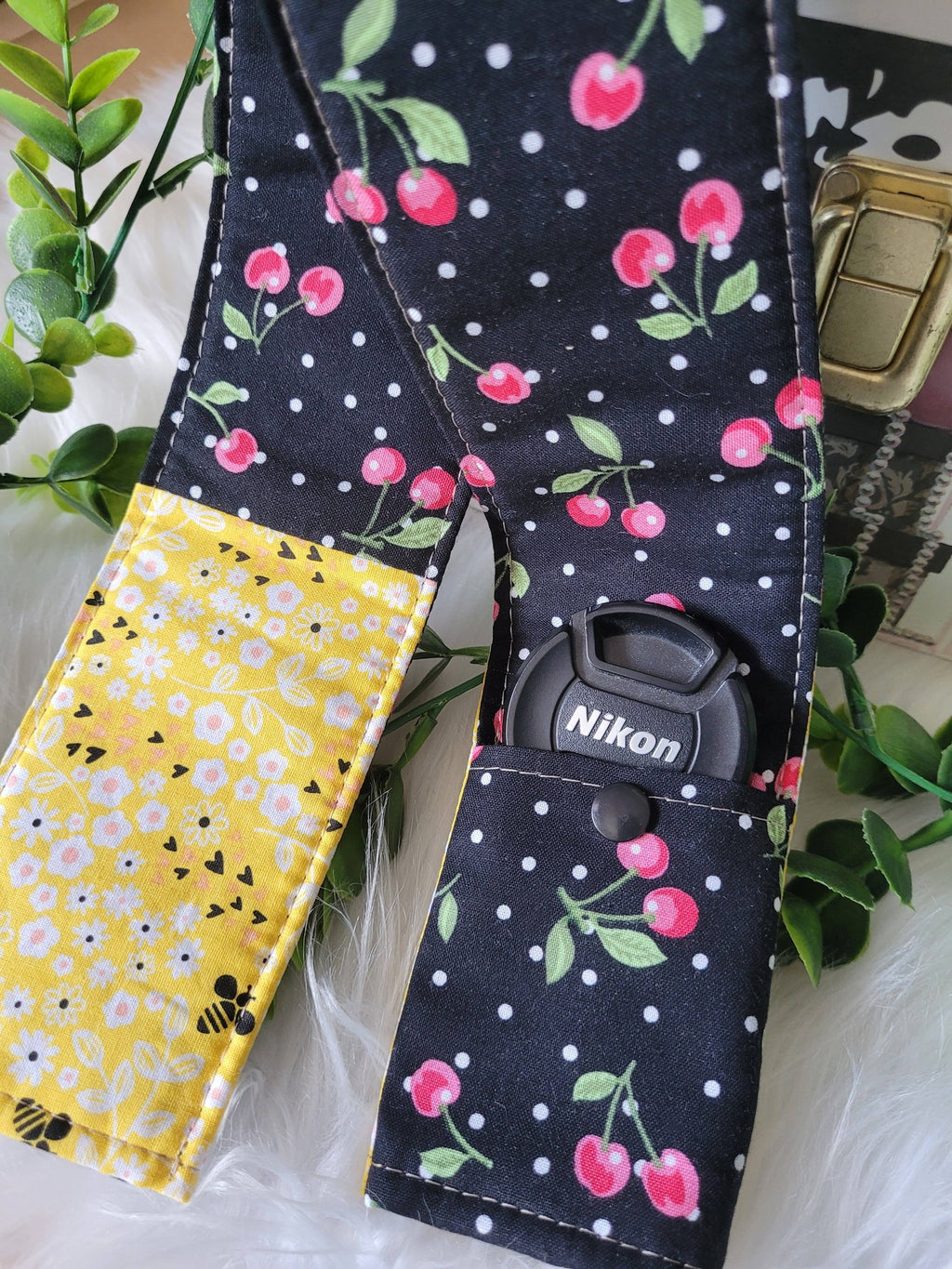 Camera strap cover with lens cap pocket